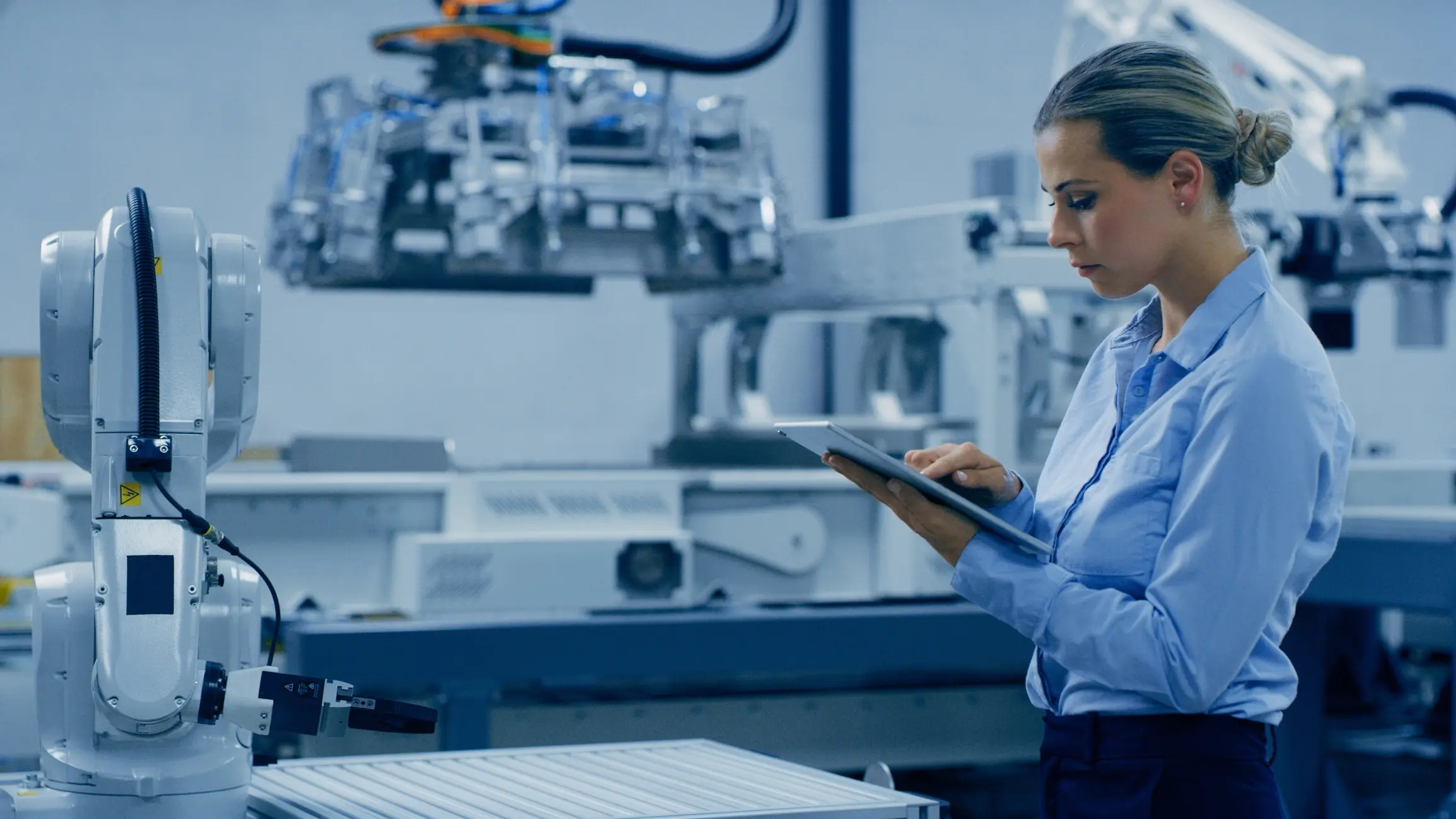 Woman using tablet in industrial setting.