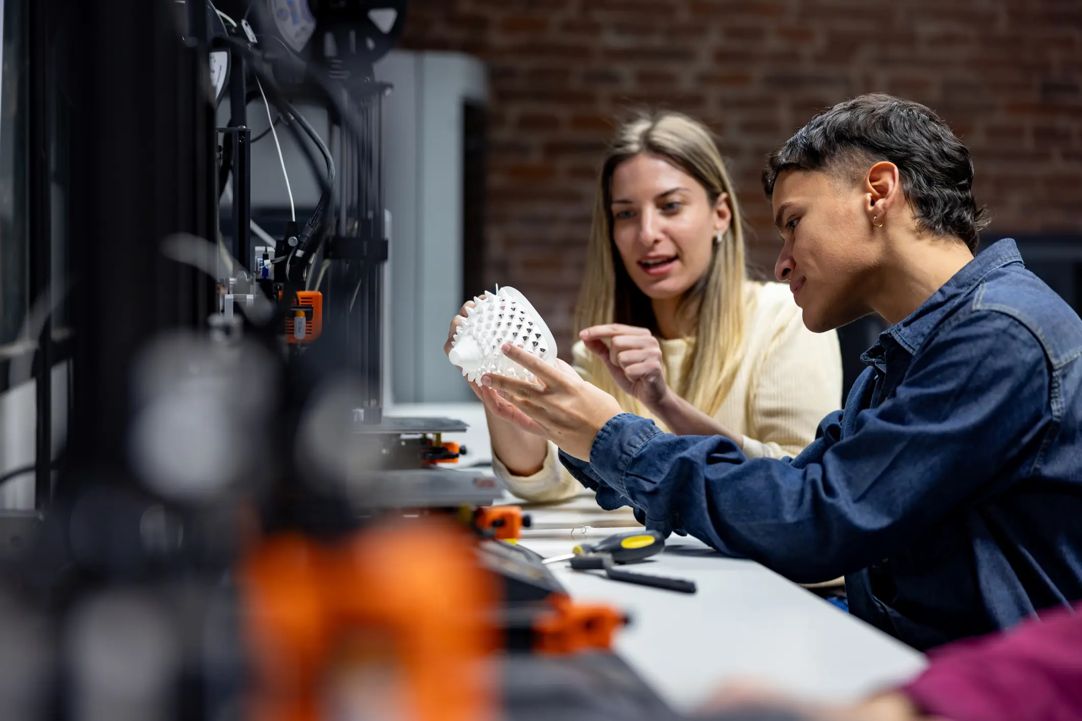 People examining a 3D-printed object together.