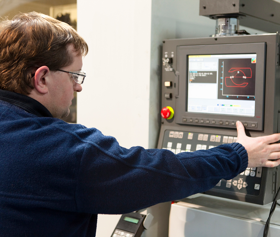 Person using industrial machine control panel.