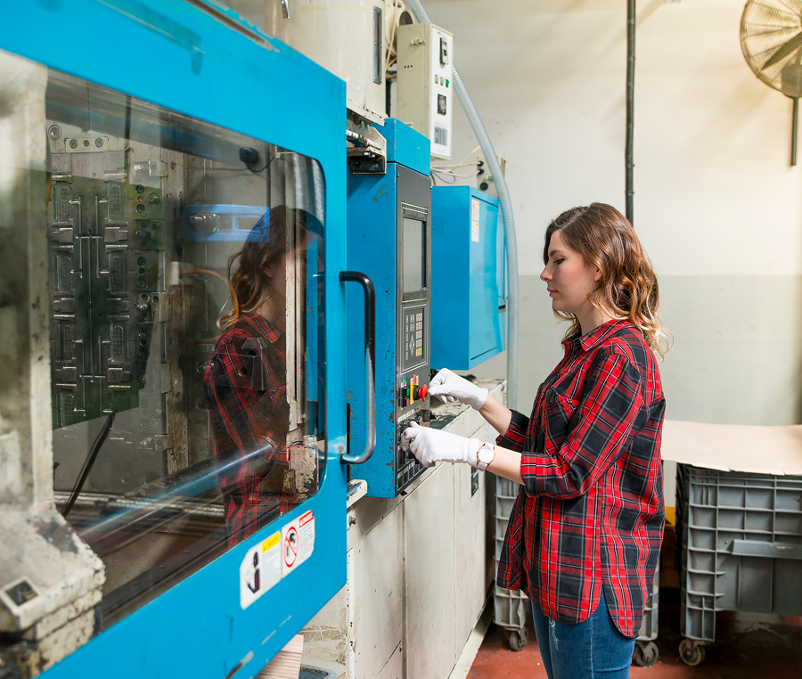 Woman operating industrial machine in factory.